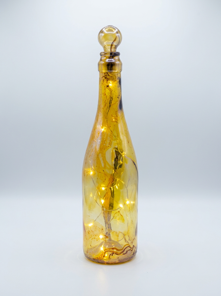 Two orange and green marbled bottles glowing with interior lights