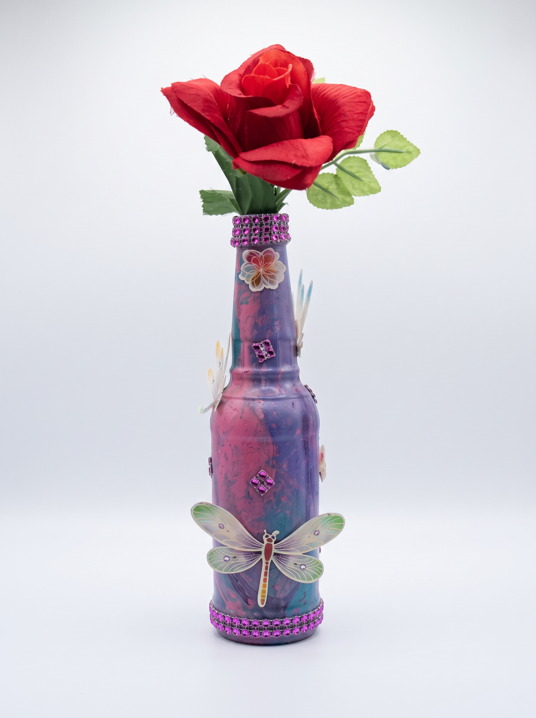 Purple and pink bottle vase with a jeweled dragonfly and red rose