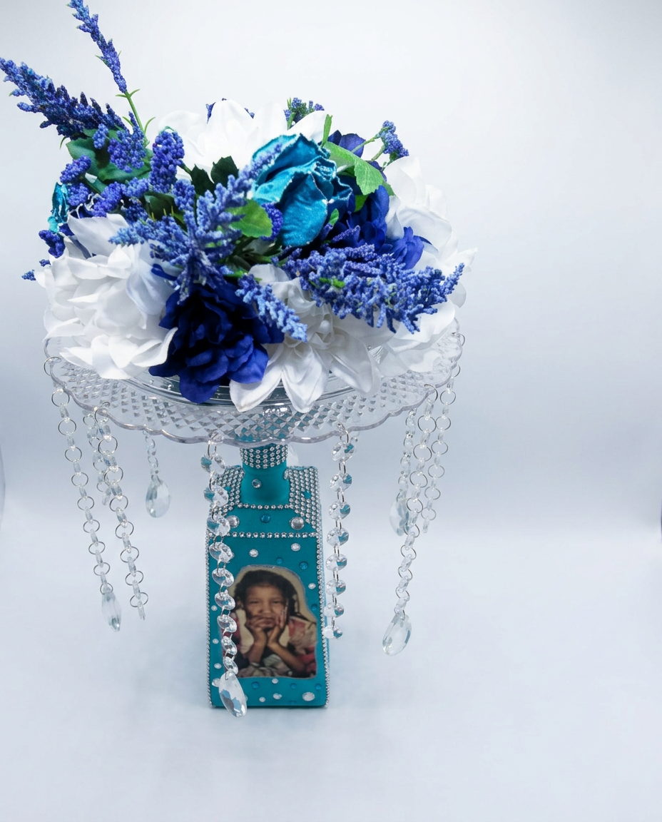 Teal memory lamp centerpiece with framed photo, white and blue flowers, and hanging crystal beads